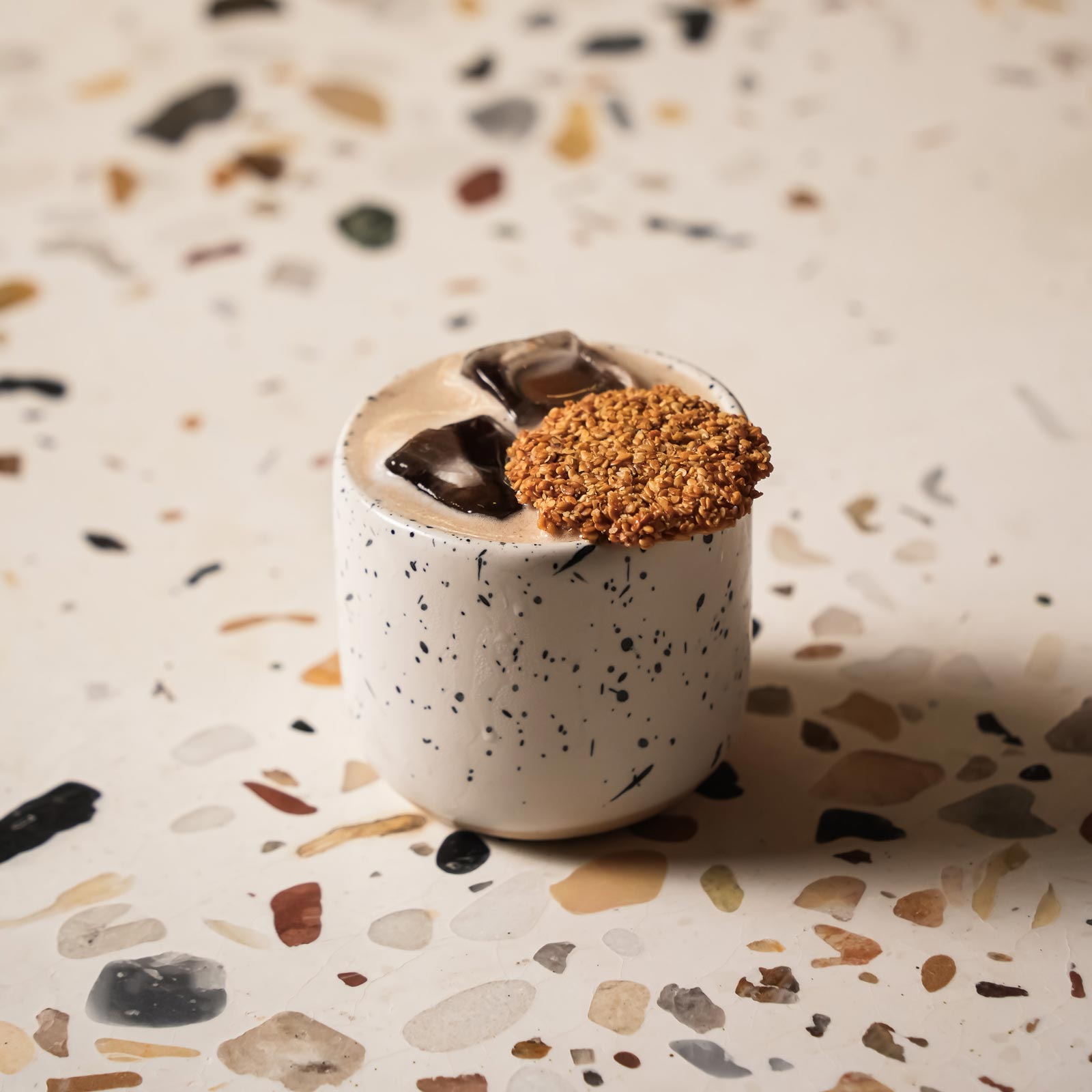 Sesame-tuile cocktail on terrazzo
